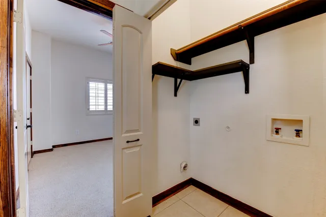 an empty room with chandelier fan and windows