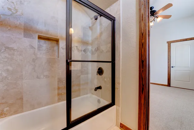 an empty room with windows and ceiling fan