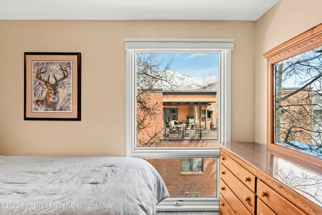 a view of a bedroom with wooden floor and a large window