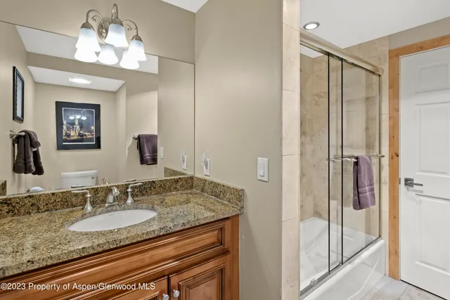 a bathroom with double vanity sinks a vanity and a shower