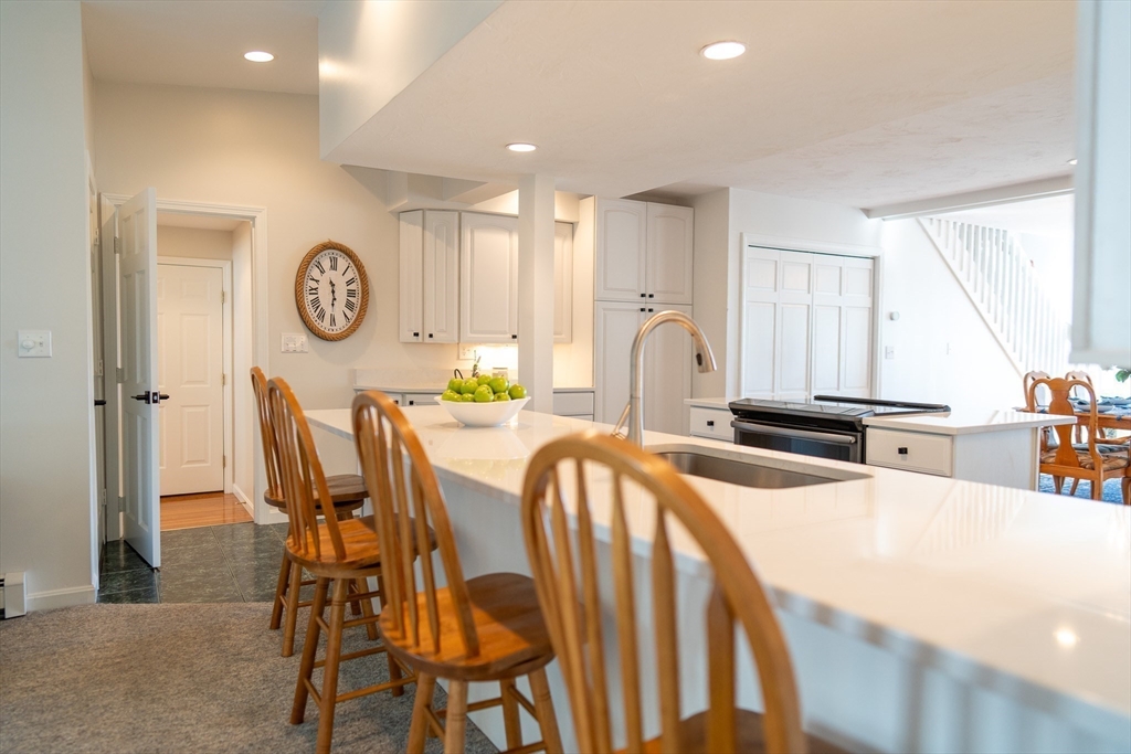 364 Lower County Road Harwich Port, MA 02646 - Photo 11 of 41 a kitchen with stainless steel appliances kitchen island granite countertop a refrigerator a stove a dining table and chairs with wooden floor