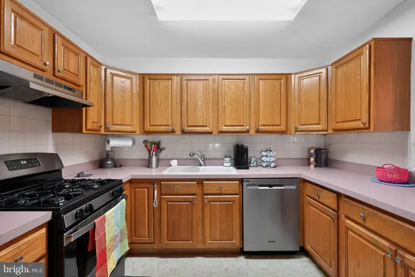 a kitchen with stainless steel appliances granite countertop a sink stove top oven and cabinets
