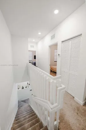 a view of a livingroom with wooden floor and staircase