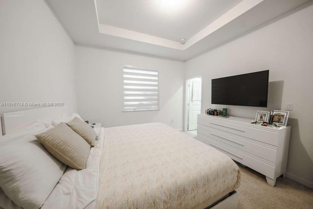 12869 Southwest 233rd Terrace Homestead, FL 33032 - Photo 19 of 30 a bedroom with a bed and a flat screen tv
