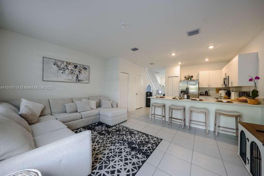 12869 Southwest 233rd Terrace Homestead, FL 33032 - Photo 2 of 30 a living room with furniture a rug and kitchen view