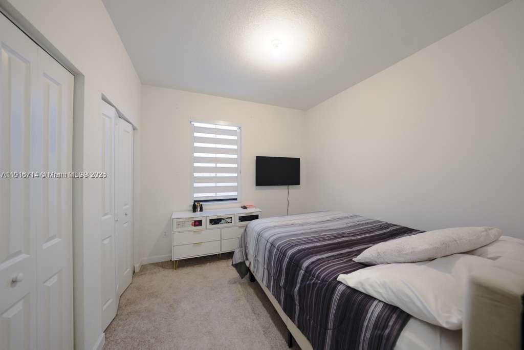 12869 Southwest 233rd Terrace Homestead, FL 33032 - Photo 23 of 30 a bedroom with a bed and a window