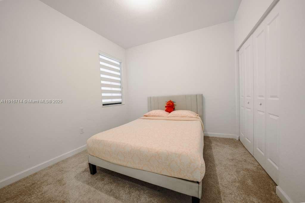 12869 Southwest 233rd Terrace Homestead, FL 33032 - Photo 24 of 30 a bedroom with a bed and window