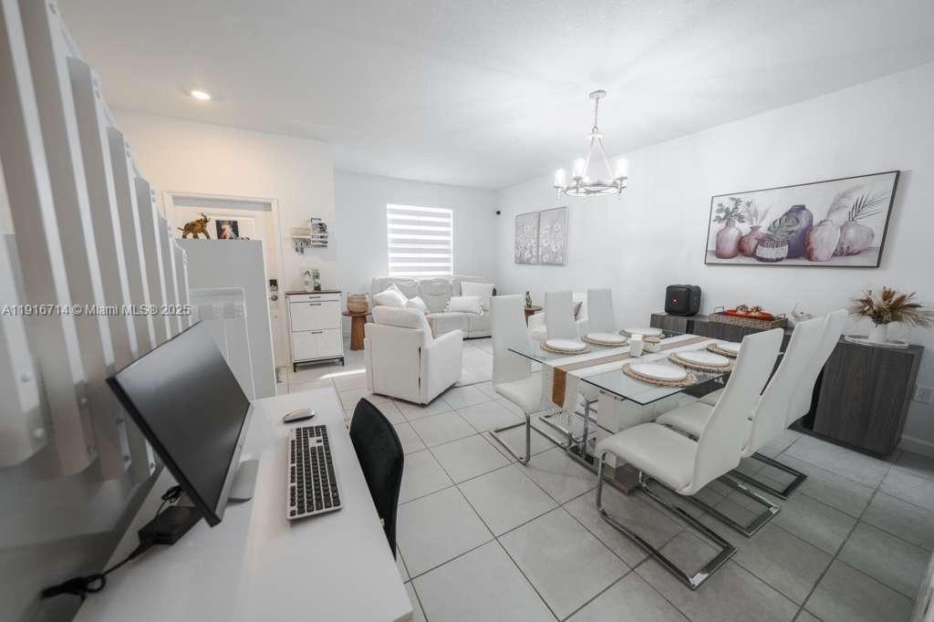 12869 Southwest 233rd Terrace Homestead, FL 33032 - Photo 4 of 30 a living room with furniture a rug and a chandelier