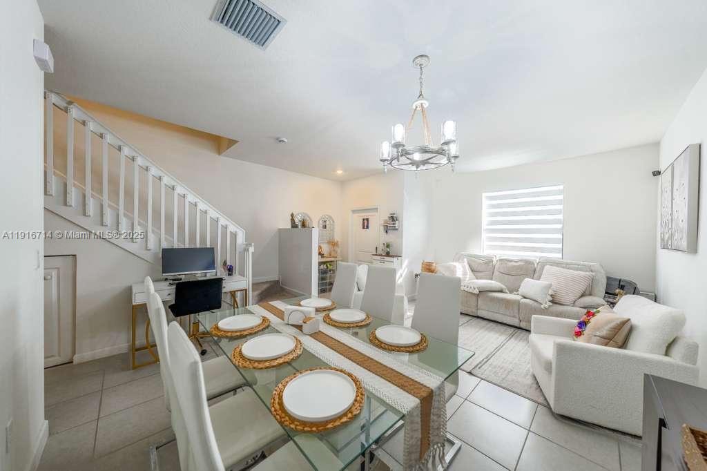 12869 Southwest 233rd Terrace Homestead, FL 33032 - Photo 6 of 30 a dining room with furniture a chandelier and wooden floor