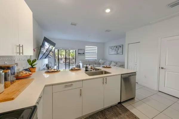 a view of a sink and dishwasher with wooden floor