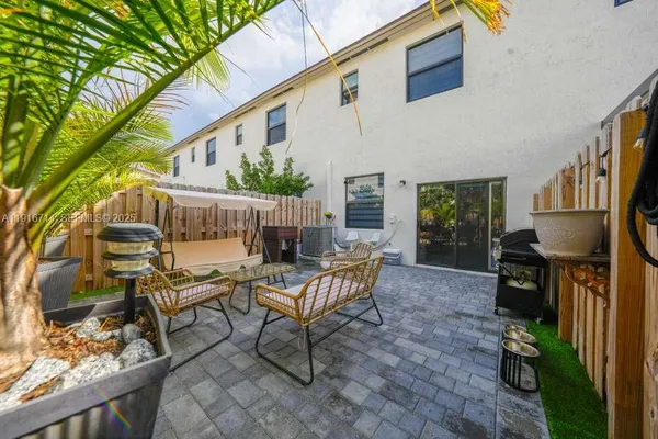 a view of a patio with table and chairs potted plants and wooden fence