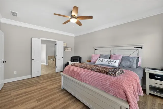 a spacious bedroom with a bed and a chandelier