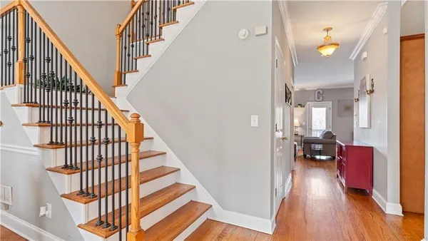 a view of a hallway with wooden floor and staircase