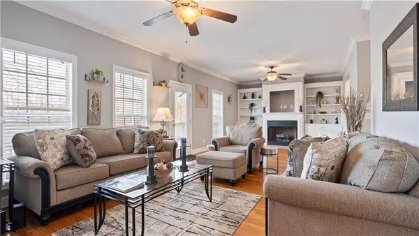a living room with furniture a fireplace and a large window