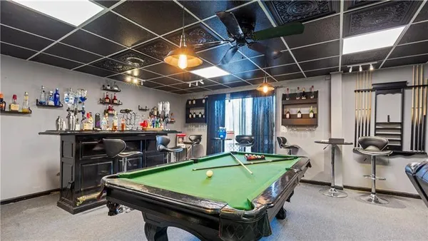 a room with pool table and windows