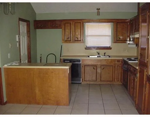 a kitchen with a sink a stove cabinets and a window