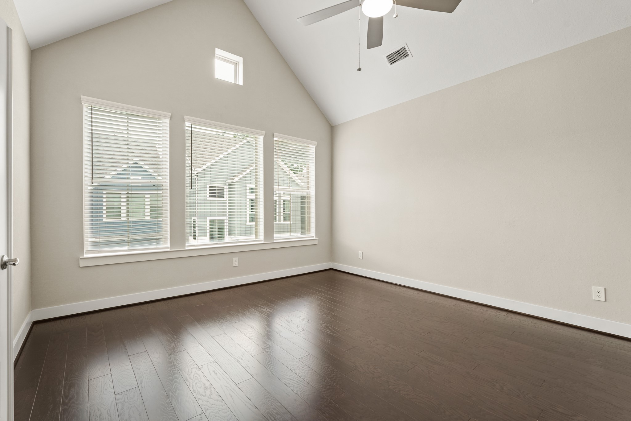 10972 Hewitt Cliff Lane Houston, TX 77043 - Photo 14 of 23 an empty room with wooden floor and windows