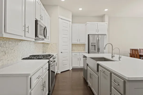 a kitchen with white cabinets appliances and sink