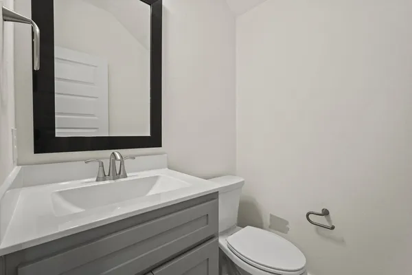 a bathroom with a sink a toilet and mirror