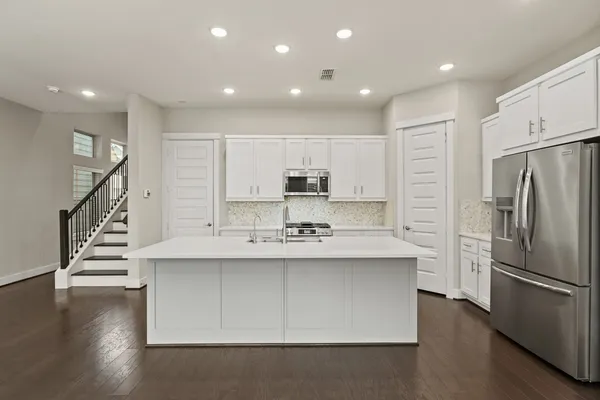 a kitchen with stainless steel appliances a sink and a refrigerator