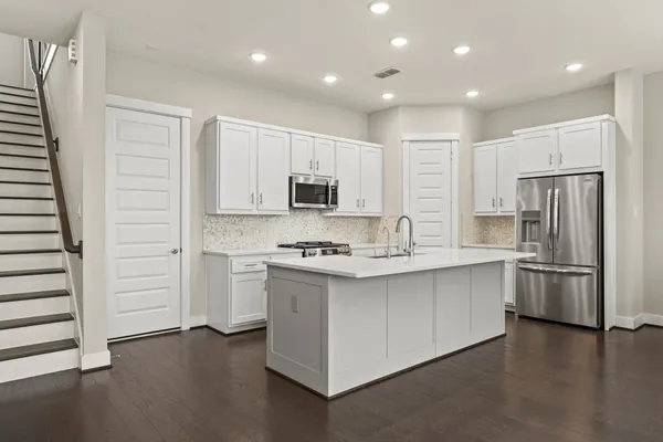 a kitchen with stainless steel appliances a stove a sink and a refrigerator
