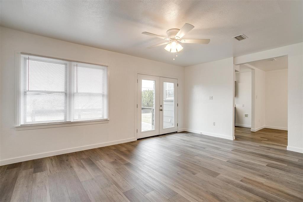 3105 Acton School Road Granbury, TX 76049 - Photo 11 of 40 a view of an empty room with wooden floor and a window