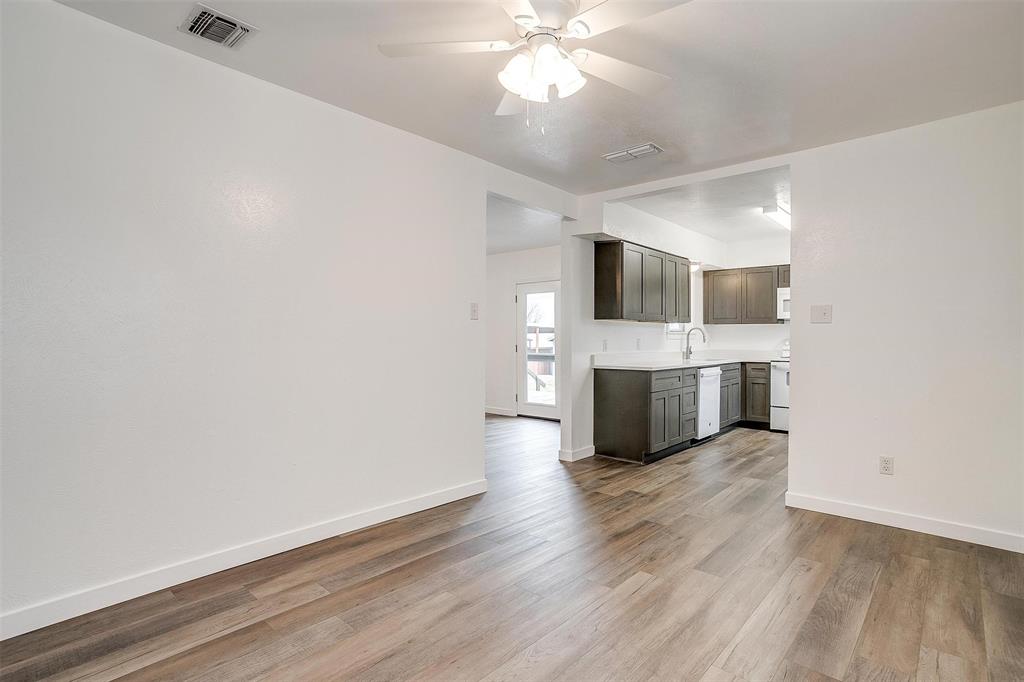 3105 Acton School Road Granbury, TX 76049 - Photo 18 of 40 a view of a kitchen with a sink a ceiling fan and wooden floor