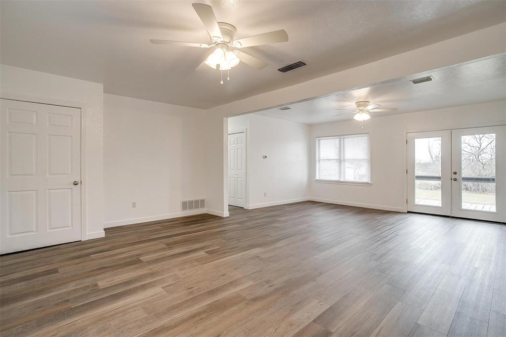 3105 Acton School Road Granbury, TX 76049 - Photo 8 of 40 an empty room with wooden floor and windows