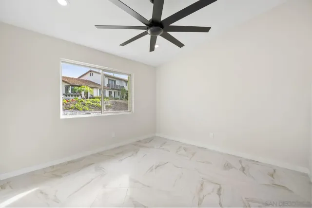an empty room with a window and a fan