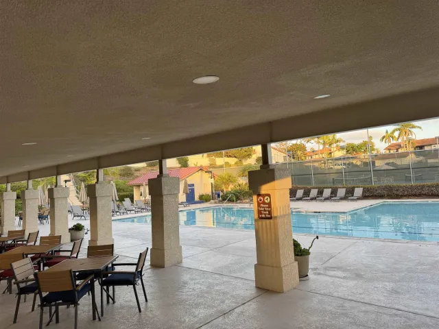 a view of a patio with a table chairs and a floor to ceiling window