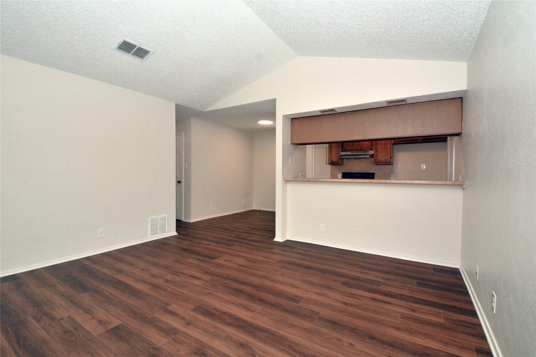 11314 Walnut Ridge Drive, Unit B Austin, TX 78753 - Photo 3 of 19 A well-lit living area features vaulted ceilings and rich wood flooring, connecting seamlessly to the kitchen.