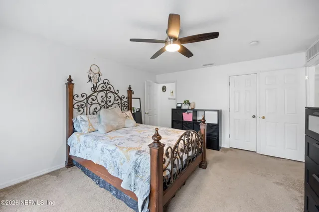 a bedroom with a bed and a ceiling fan