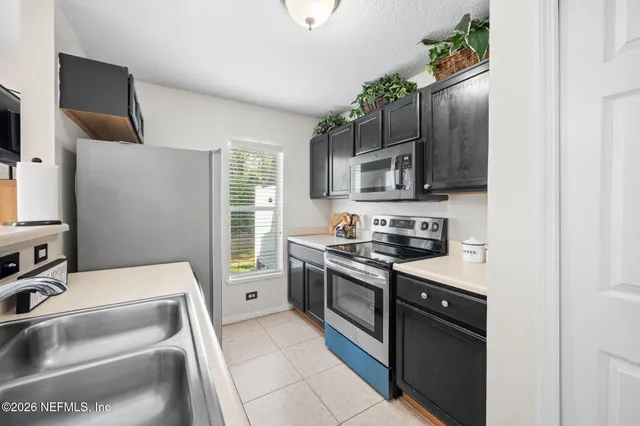 a kitchen with stainless steel appliances granite countertop a sink and a stove