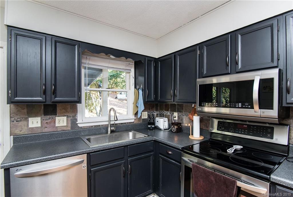 4043 Windward Drive Tega Cay, SC 29708 - Photo 9 of 25 a kitchen with wooden cabinets a sink and a stove top oven