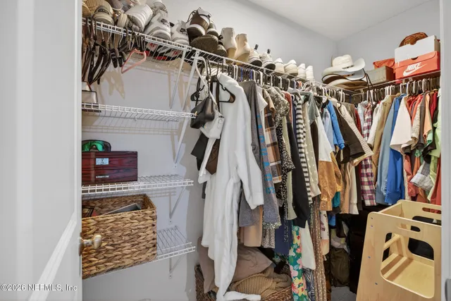 a view of walk in closet with clothes