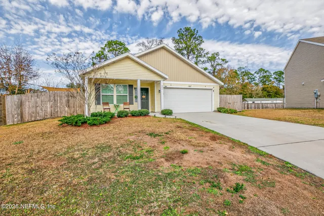 a view of a house with a yard and potted plants
