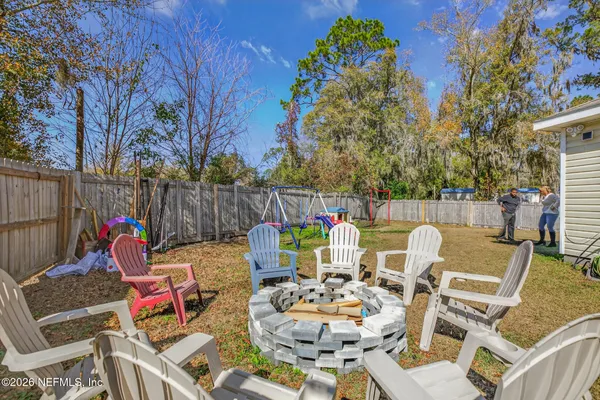 a view of a chairs and table in the back yard of the house