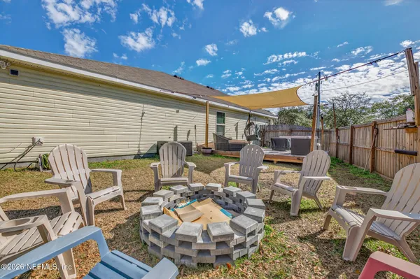 a view of a patio with table and chairs with wooden floor and fence