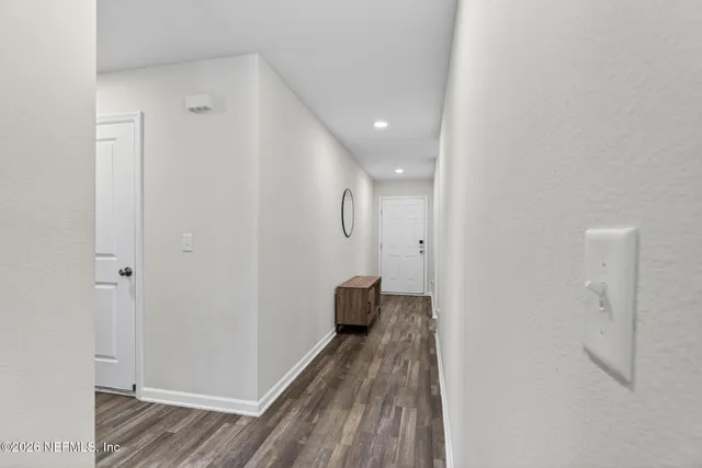 a view of a hallway with wooden floor and closet