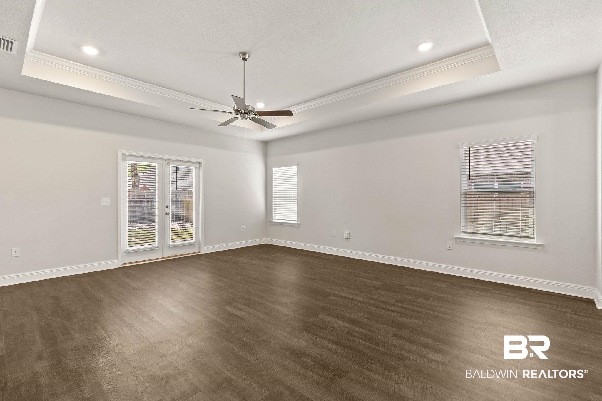 9448 Amethyst Drive Daphne, AL 36526 - Photo 9 of 61 Empty room with french doors, dark wood finished floors, crown molding, a ceiling fan, and recessed lighting