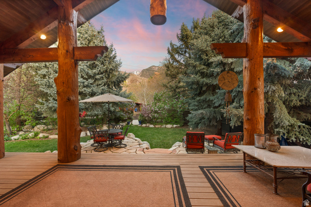 10280 Dimple Dell Road Sandy, UT 84092 - Photo 17 of 58 Deck at dusk featuring a patio, outdoor lounge area, and a lawn