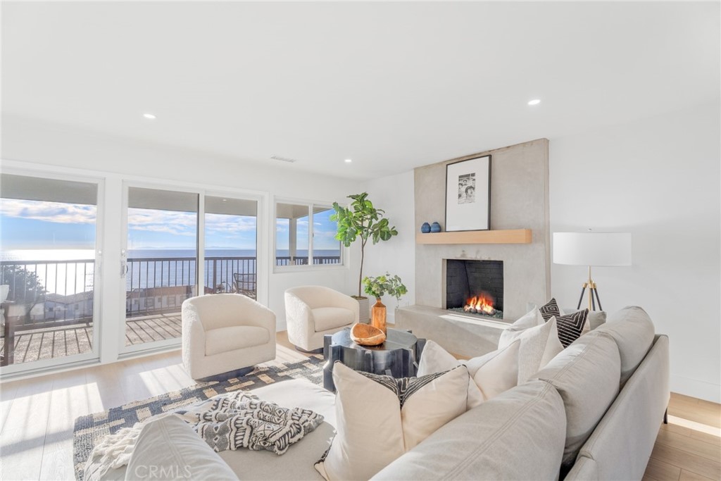 a living room with furniture a fireplace and a large window