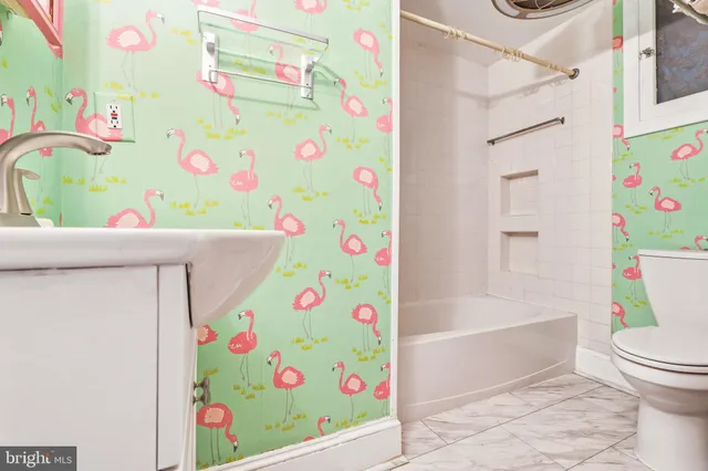 a view of a hallway with wooden floor and a bathroom