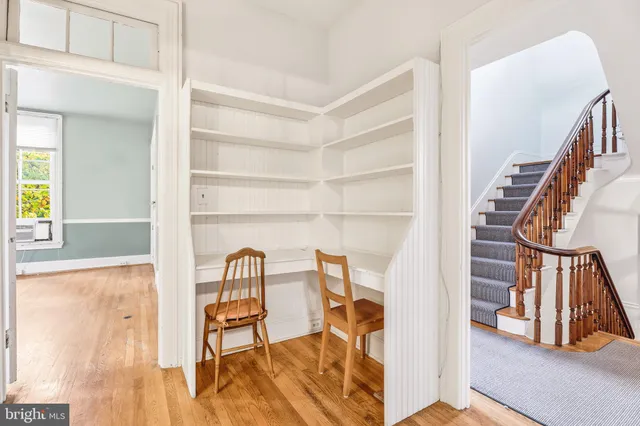 a view of a room with wooden floor and a ceiling fan