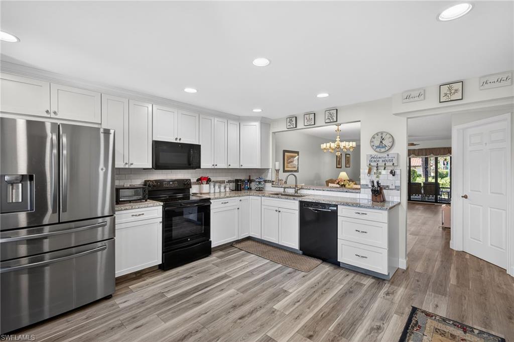 a kitchen with a refrigerator stove top oven and cabinets