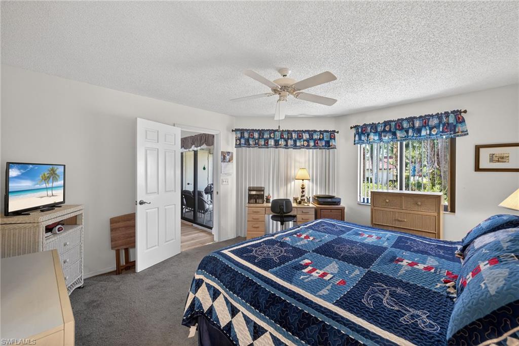 4973 Pepper Circle, Unit F105 Naples, FL 34113 - Photo 11 of 21 a living room with furniture and a flat screen tv