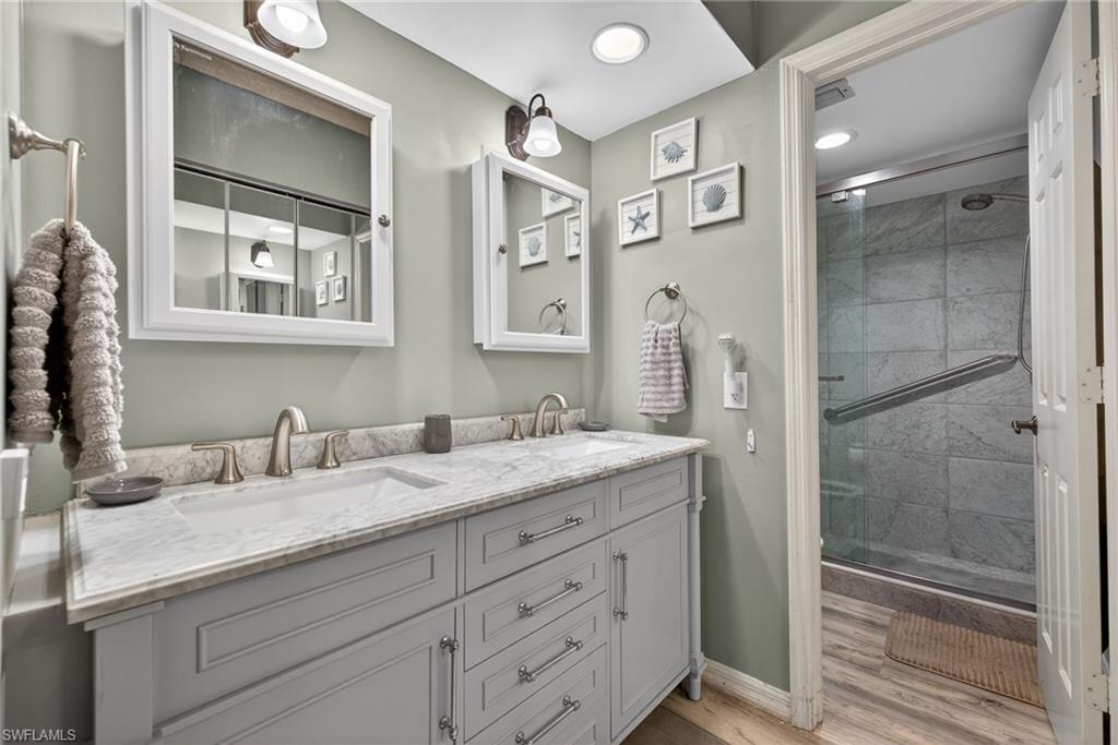 4973 Pepper Circle, Unit F105 Naples, FL 34113 - Photo 12 of 21 a bathroom with a granite countertop sink mirror and double