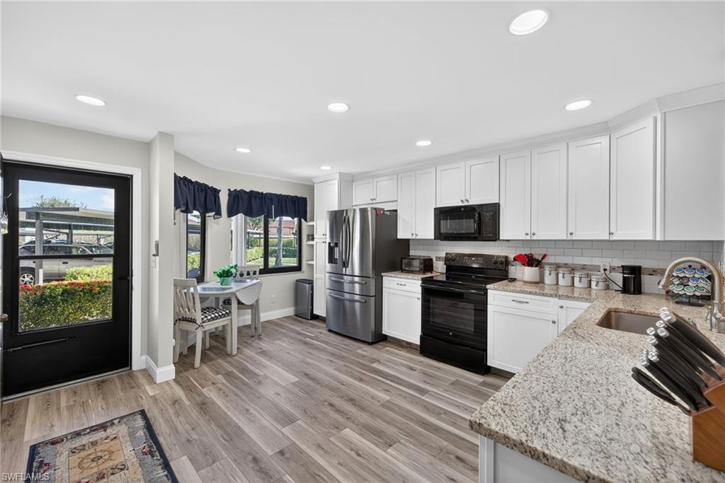 4973 Pepper Circle, Unit F105 Naples, FL 34113 - Photo 2 of 21 a kitchen with stainless steel appliances granite countertop a refrigerator stove microwave and sink