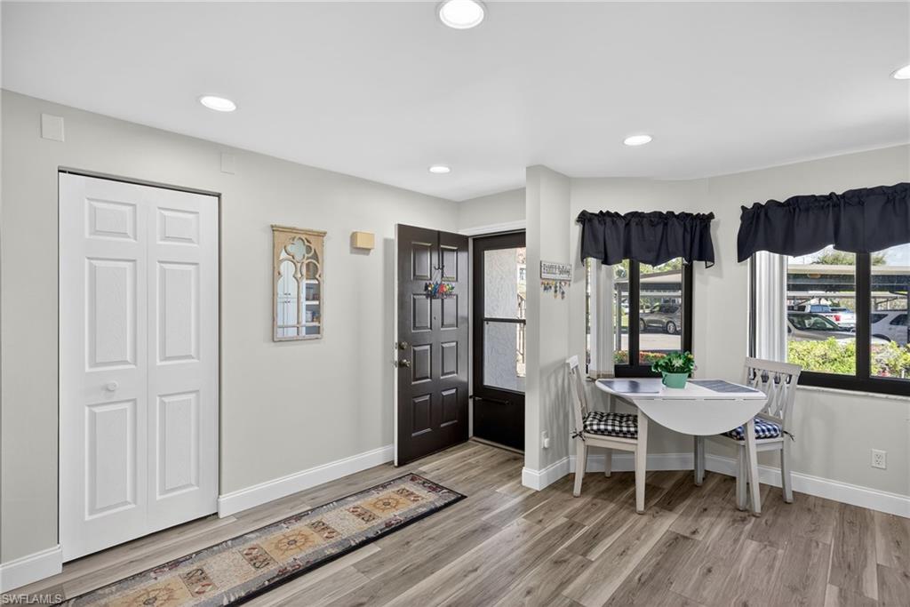 4973 Pepper Circle, Unit F105 Naples, FL 34113 - Photo 4 of 21 a view of a dining room with furniture and wooden floor