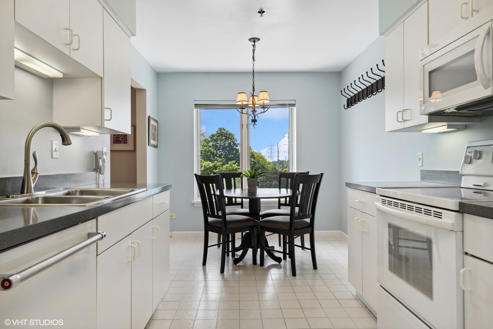 308 North Happ Road, Unit 310 Northfield, IL 60093 - Photo 5 of 17 a kitchen with stainless steel appliances granite countertop a stove a sink dishwasher a dining table and chairs with wooden floor